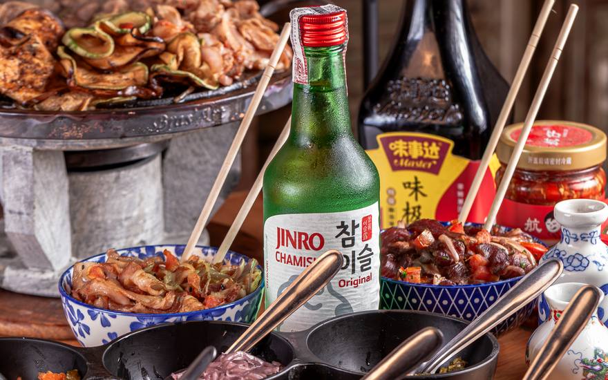 Chapa de churrasco coreano na mesa, com acompanhamentos